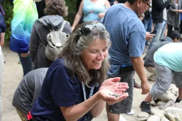 Lady on beach holding hermit crab