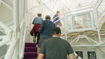 visitors walk up stairs to library